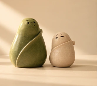 寄り添って休む緑と白の陶器のキャラクター